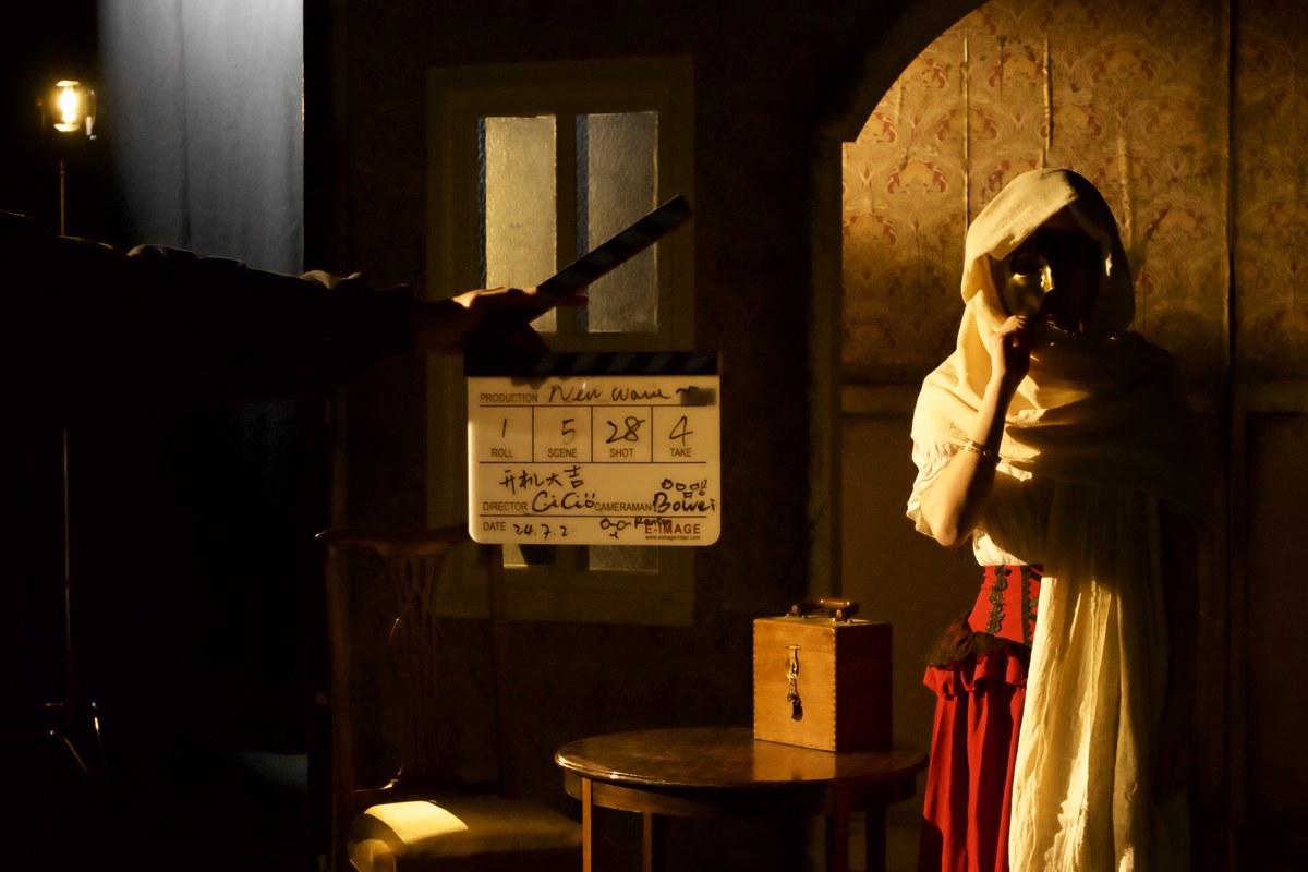 clapperboard held up before a masked performer