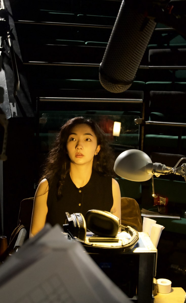 boom mic overhead, light across her face