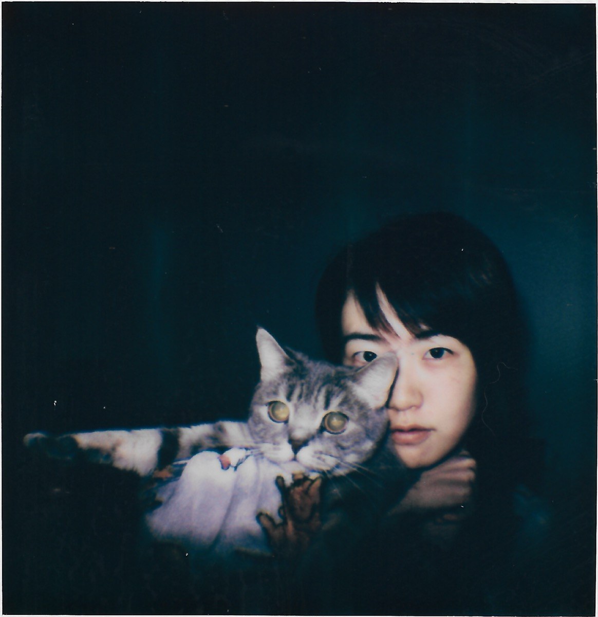 self-portrait in the dark, holding a cat